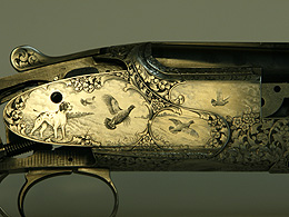 Close-up of engraved gun showing hunting dog and wild fowl